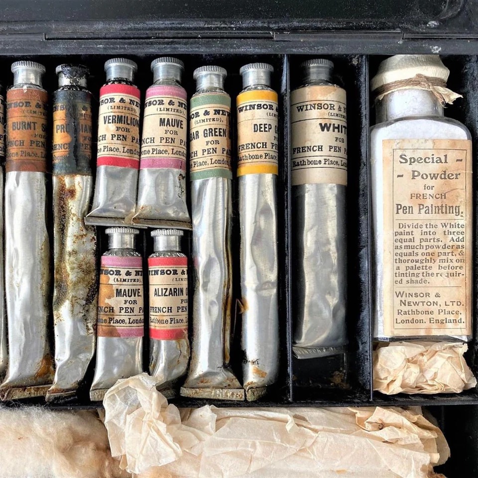 The infrastructure of spontaneity: a box of Winsor & Newton collapsible tubes, Rathbone Place, London. Vermilion, mauve, deep gold, still squeezed the way somebody left them.